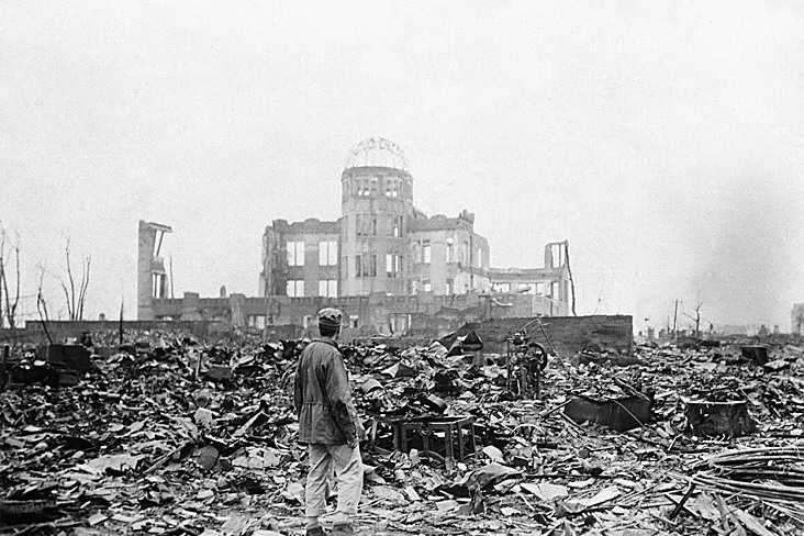 1945年8月6日，美國為迫使日本投降，在日本廣島投擲一個原子彈，據估計造成約14萬人死亡。圖為同年9月8日，一名盟軍記者站在已變成一片廢墟的廣島市中心，遠處為一家電影院殘存物。美聯社