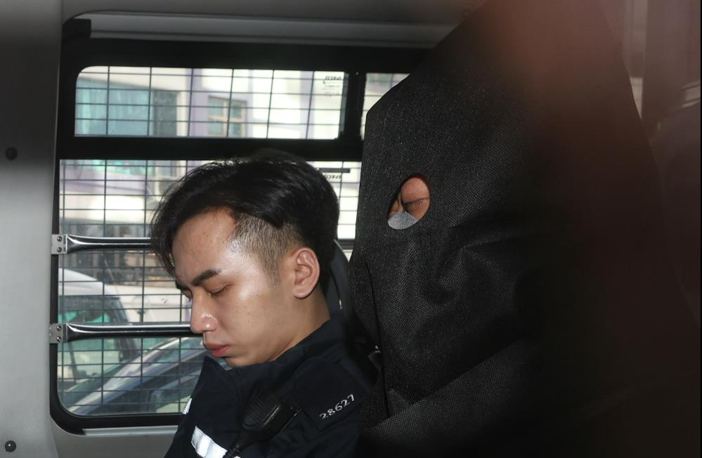 涉嫌協助蔡天鳳前夫逃亡的被告林舜（黑布蓋頭者）由警車押送至法院。（香港01）