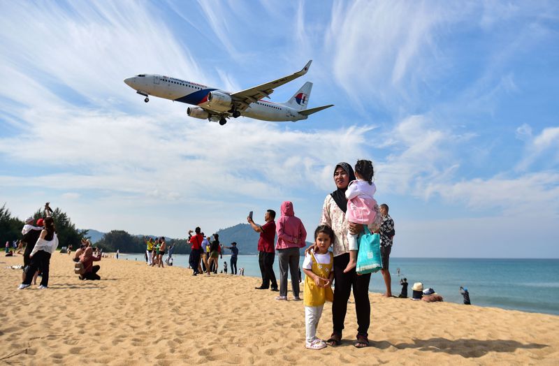普吉島邁考（Mai Khao）海灘上空，一台準備在普吉國際機場降落的飛機低空掠過。法新社