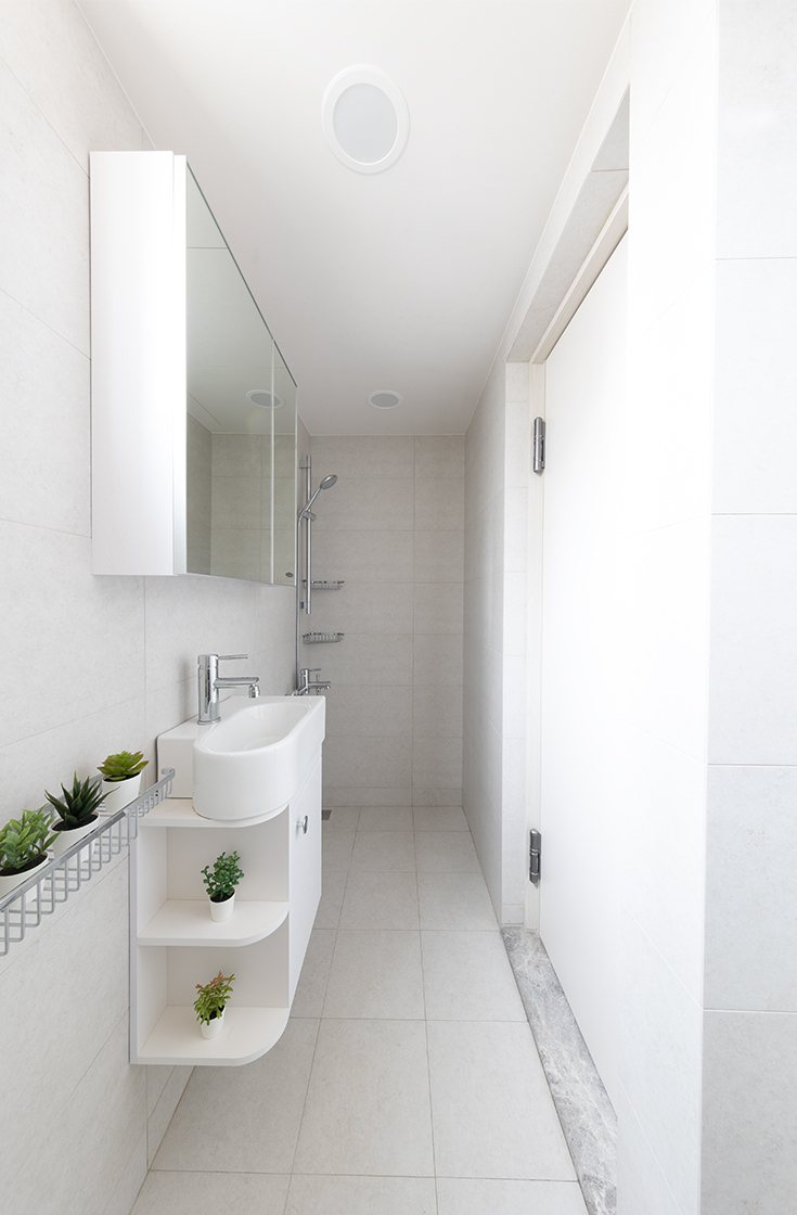 浴室格局設計為長方型緣故，設計師融入日式元素，明亮的白點綴著綠意植栽，讓人在沐浴...