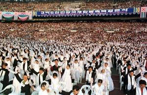 統一教相信跨國配婚可以帶來世界和平。圖為1999年在漢城奧運體育場舉行的集團婚禮，有大約4萬對夫妻參加。路透