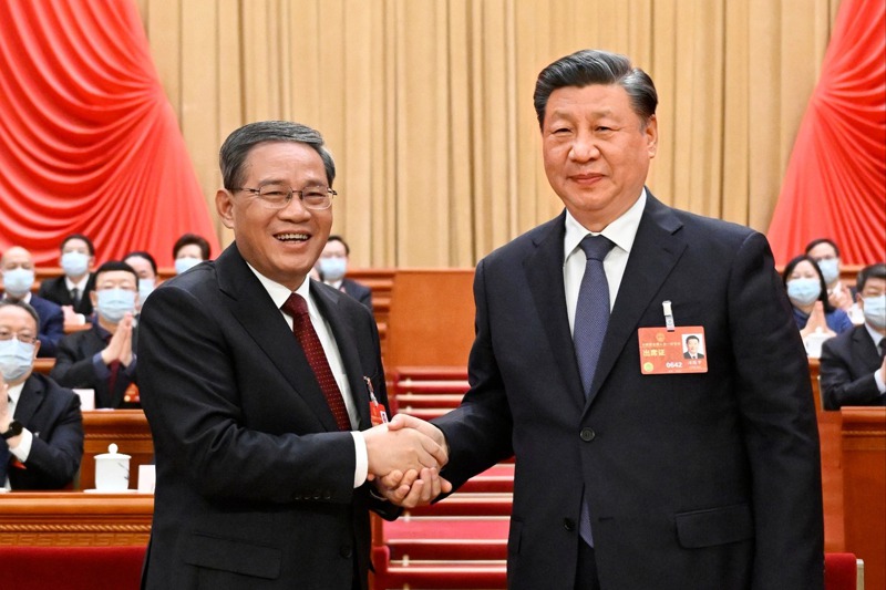 大陸新一屆政府換屆完成。圖為李強（左）獲選為國務院總理後，與連任大陸國家主席的中共總書記習近平（右）握手。新華社