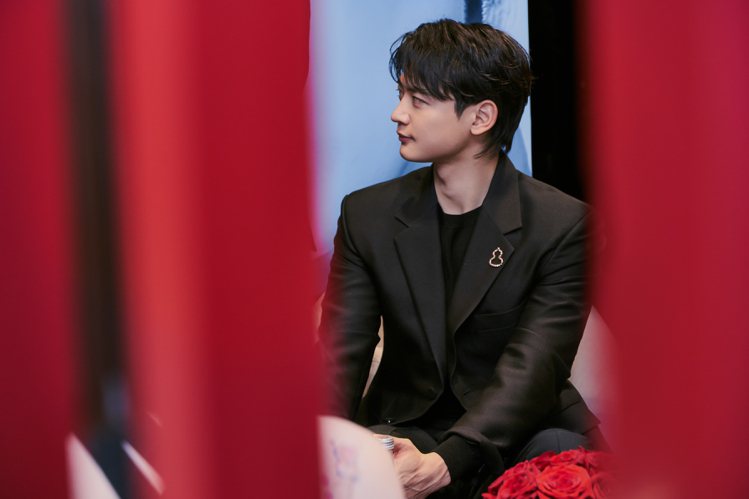 一身黑色西裝搭配玫瑰金胸針珠寶的崔珉豪，讓人發現男士坐姿也能如此高雅大方。圖／Qeelin提供
