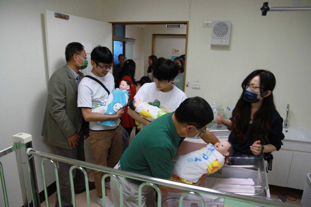 新竹西南扶輪社友在元培護理系老師指導下體驗抱新生嬰兒。 元培/提供