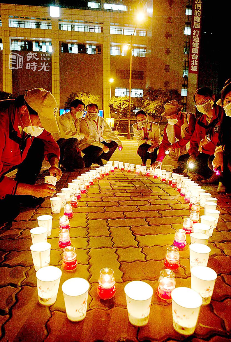 我們守夜，你們別怕青商會員昨晚在和平醫院前點著圍繞成台灣形狀的蠟燭，為院內和SARS奮戰的醫護群及台灣島祈福。圖／聯合報系資料照（2003/04/29　胡國威攝影）
