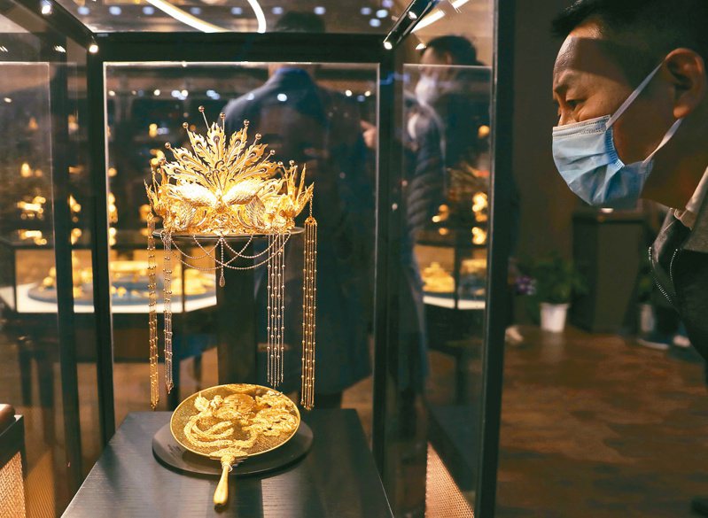 今年春節到元宵節期間中國黃金消費呈現快速回暖現象。圖為中國國際珠寶展3月16日在北京中國國際展覽中心開幕，觀眾欣賞黃金工藝品。（中新社）