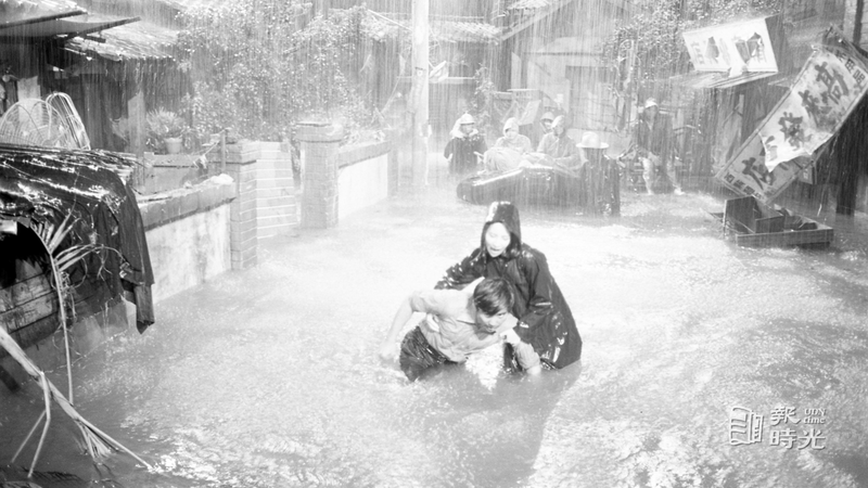 「汪洋中的一條船」內景拍攝逼真，林鳳嬌和秦漢在大雨中，邊躲避飛舞的破招牌邊逃命。圖／聯合報系資料照（1978/04/06　龍啟文攝影）
