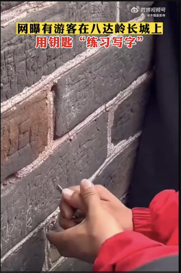 據新浪微博影片，3月21日在八達嶺景區遊玩時，在長城牆體上刻字。孟某被警方抓獲後，將被處以罰鍰和行政拘留。（取自微博視頻）