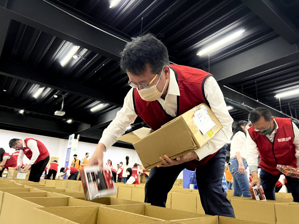和潤企業總經理林彥良與同仁一起包裝食物箱。業者提供