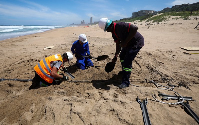 美中竞争范围扩张到海底电缆的铺设。图为南非海滩工人正在铺设海底电缆。（路透资料照片）(photo:UDN)
