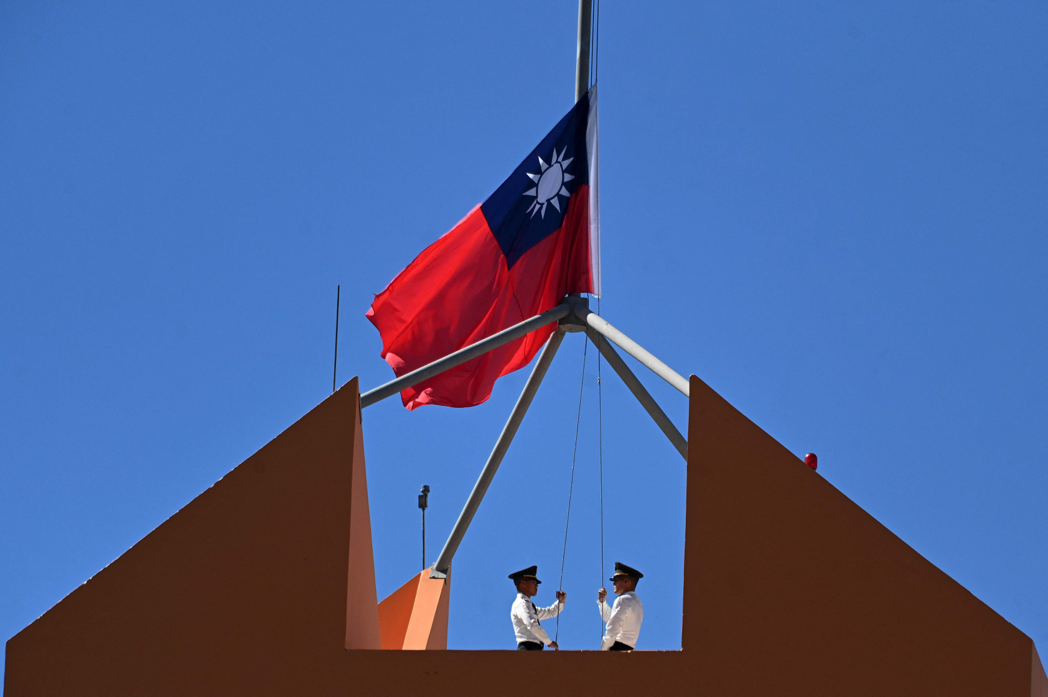 26日兩國斷交後，我駐宏都拉斯大使館的國旗緩緩降下。（法新社）