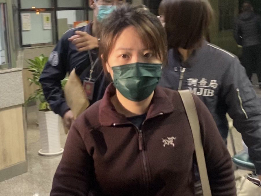林女被移送新北地檢署複訊，面對記者未回應，僅出手示意「不要拍」。記者柯毓庭／攝影