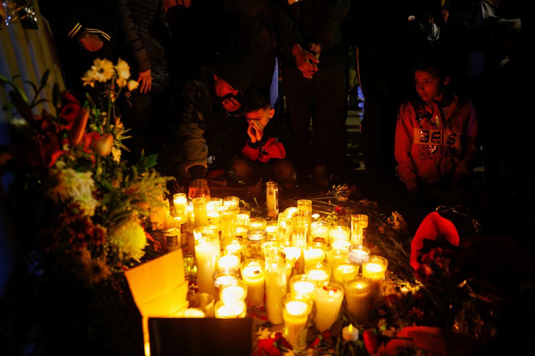 死傷移民得親屬在拘留所外點蠟燭哀悼。 圖／路透社