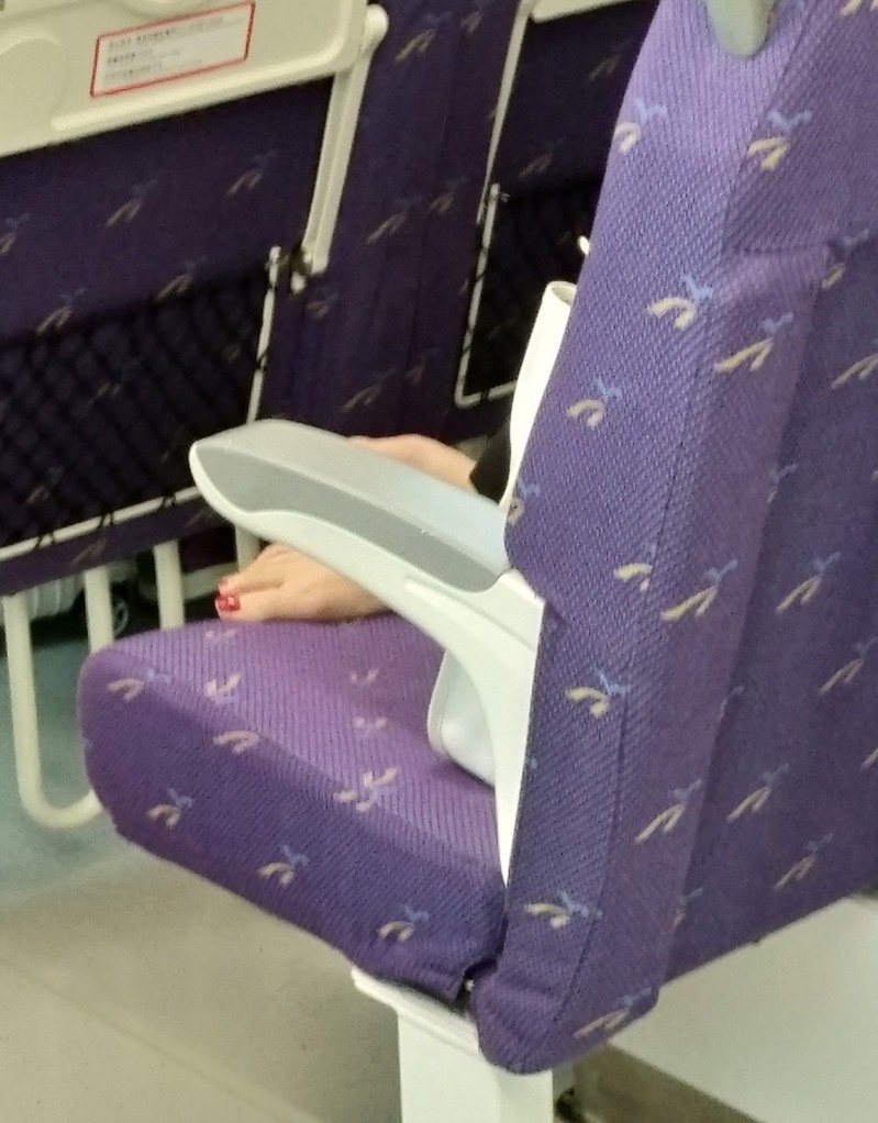 一名網友抱怨桃園機場捷運的某位乘客，一人占用兩人座位，還赤腳躺在椅子上。圖擷自臉書社團「爆怨2公社」