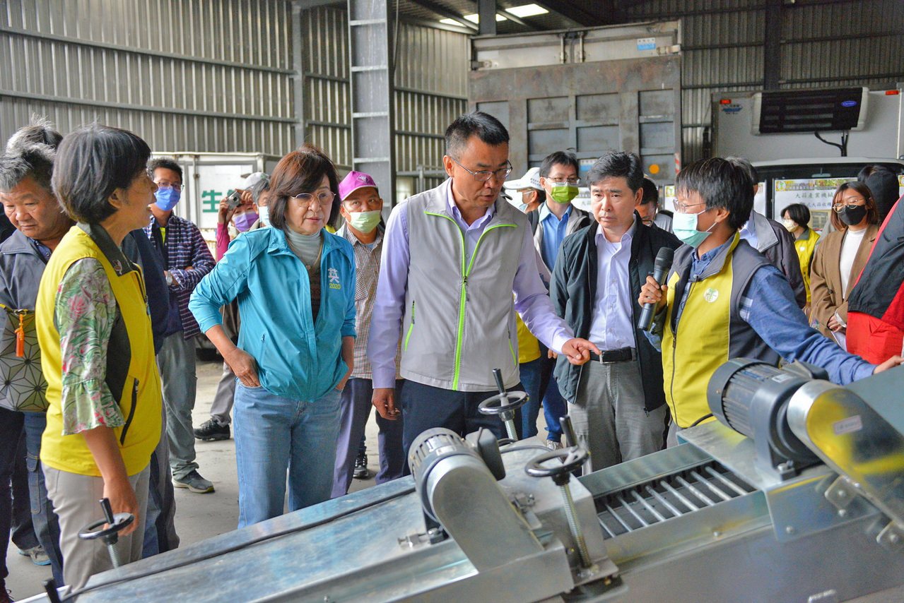 王志瑋助理研究員(手拿麥克風者)向陳吉仲主委介紹本場研發的篩土集裝機。 台南農改場/提供。