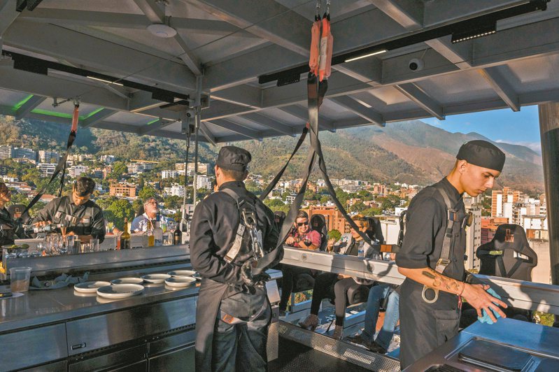 委內瑞拉首都卡拉卡斯的餐廳「Al tum」賣點為用起重機吊在半空中。（紐約時報）