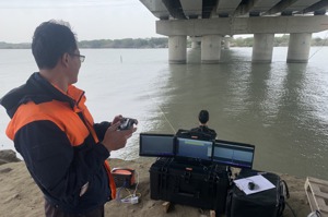台南市消防人員在岸邊遙控水下機機器人，並透過水下機機器人攝影機回傳電腦影像，監看水下狀況。圖／台南市消防局提供