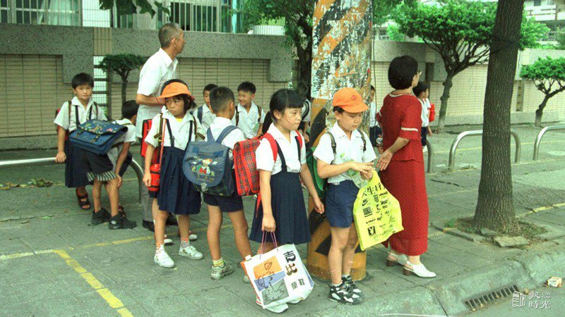 新生昨天報到，中午放學，老師帶著小朋友排隊等公車。圖／聯合報系資料照（1998/08/31 張柏福攝影）
