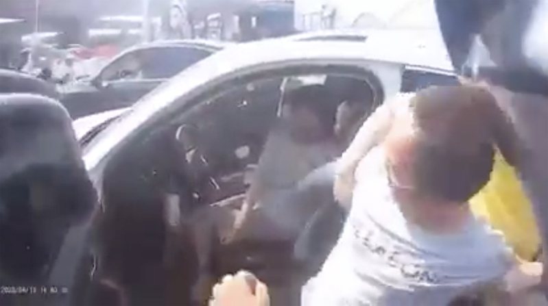 一名失控男子疑似強行闖入車子，由善心民眾幫忙，壓制該名男子。圖／翻攝爆廢公社