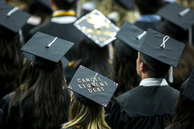 大學學費昂貴，學生未出社會就背負沉重學貸。圖為愛荷華大學畢業典禮上，學士帽上有著「取消學貸」的字樣。（圖／美聯社）