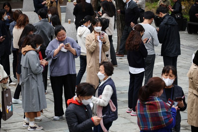 南韩民众群聚在首尔美术馆外疯「抓钱」，赚取app给予的小额现金奖励。路透(photo:UDN)