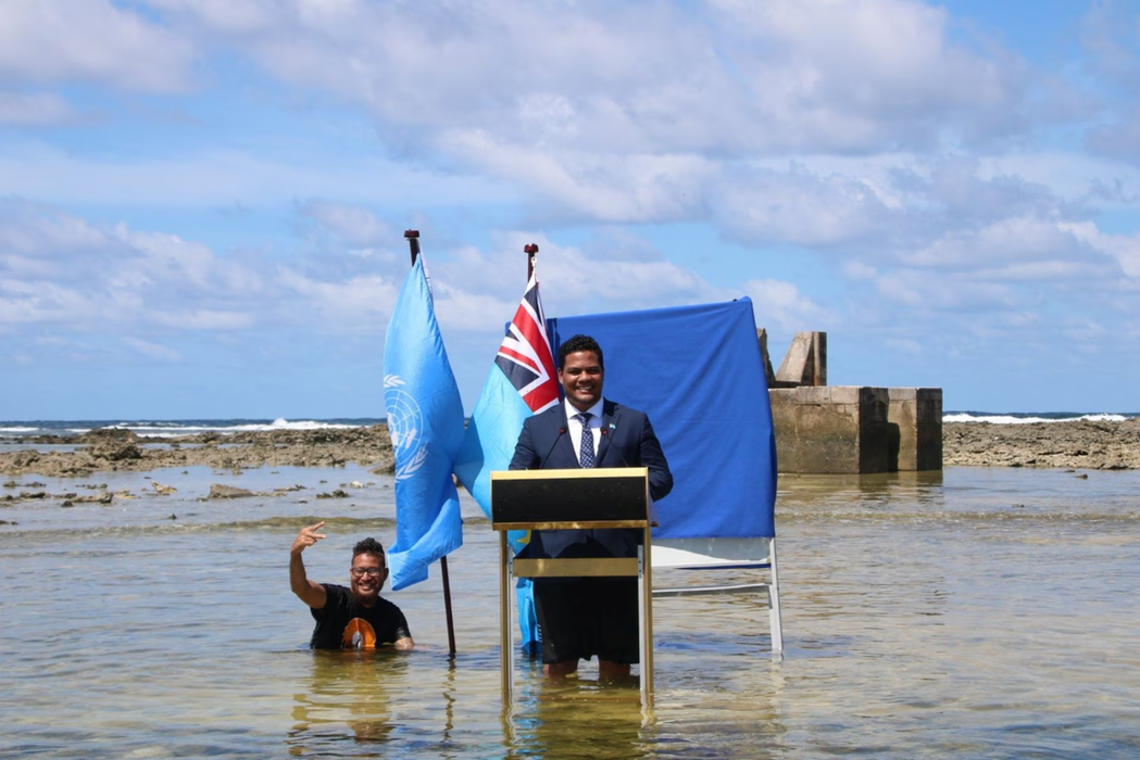 2021年，太平洋小島國吐瓦魯外交部長柯飛（Simon Kofe）站在水深及膝的...