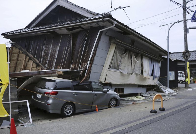 日本石川縣能登地區今天發生強震，有建築物倒塌壓到路邊停放的轎車。美聯社