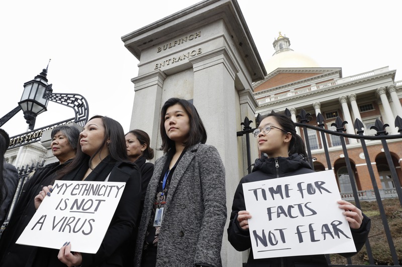 美國麻州亞裔美國人委員會2020年拿著「我的族裔不是病毒」和「該面對事實了，不要害怕」等標語牌，抗議新冠疫情期間針對亞裔的歧視和攻擊。美聯社