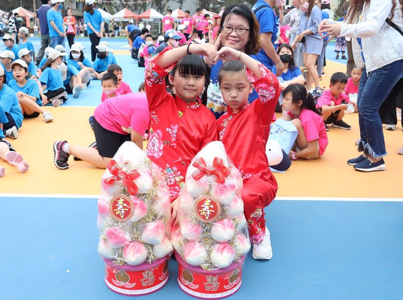 野柳國小的孩子們送上了壽桃和獻唱生日快樂組曲，祝福萬里國小與野柳國小都生日快樂。 圖／紅樹林有線電視提供