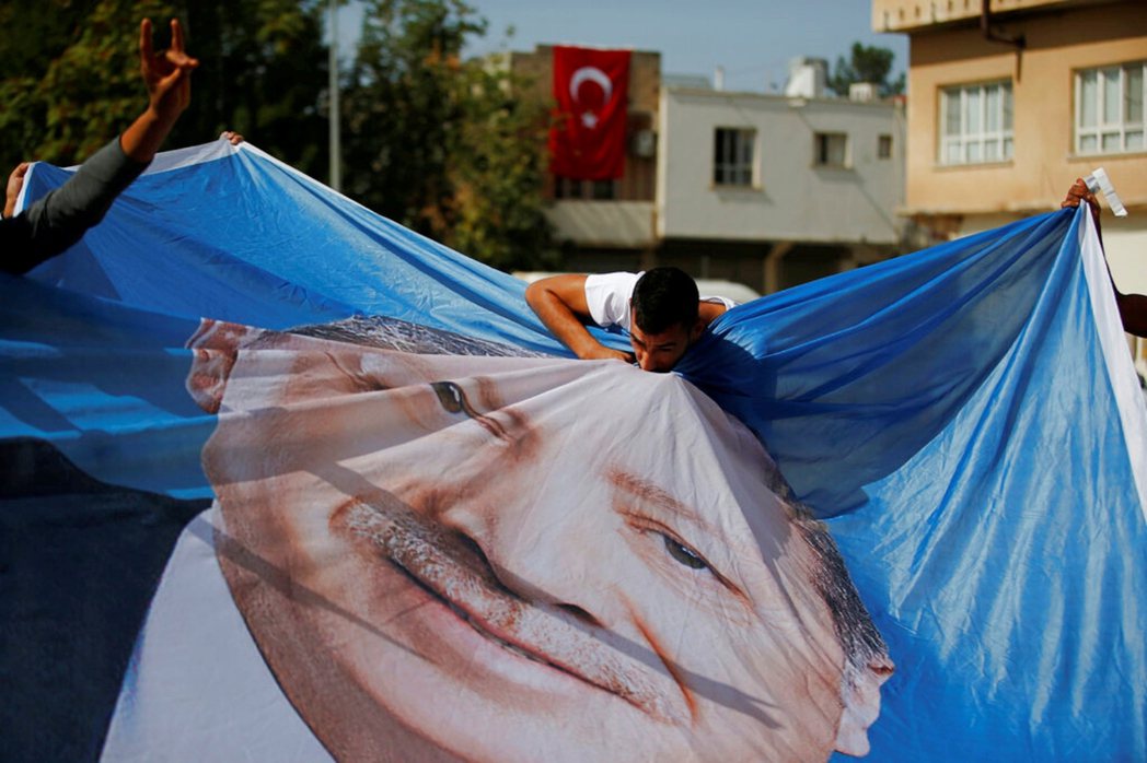 土耳其東南部邊境城鎮阿克恰卡萊，一名敘利亞男子親吻土耳其總統厄多安的旗幟。 圖／...