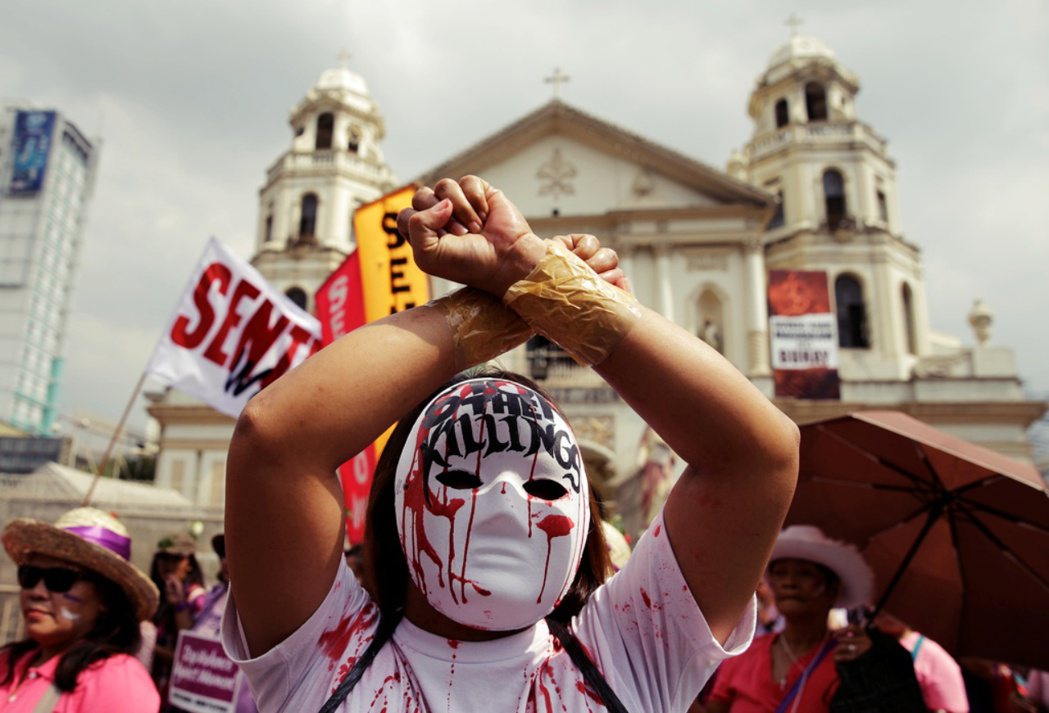 2017年，戴著面具的示威者在菲律賓馬尼拉參與國際婦女節集會，抗議菲律賓國會恢復...