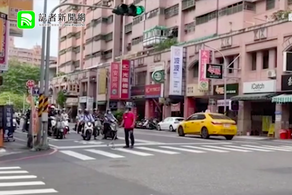 民眾在台南市北門路二段路口，看到一排機車騎士禮讓老翁過馬路。圖擷自記者新聞網