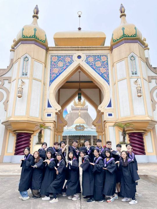 ▲畢業生穿著學士服在六福村金碧輝煌的阿拉伯皇宮前拍團體照。　圖：六福村主題遊樂園／提供