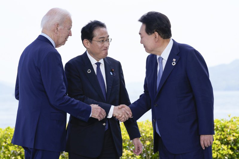 美國總統拜登(左)21日在廣島的G7峰會場邊與日本首相岸田文雄(中)和南韓總統尹錫悅(右) 會談。美聯社