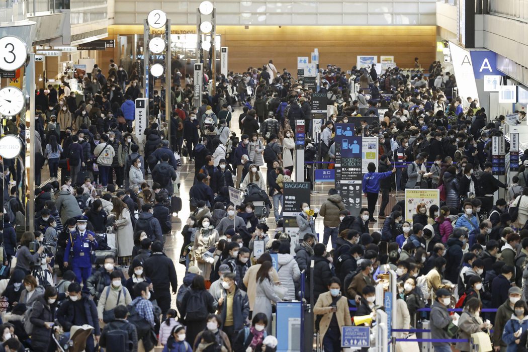 旅客去年10月擠在日本東京羽田機場出境大廳。美聯社