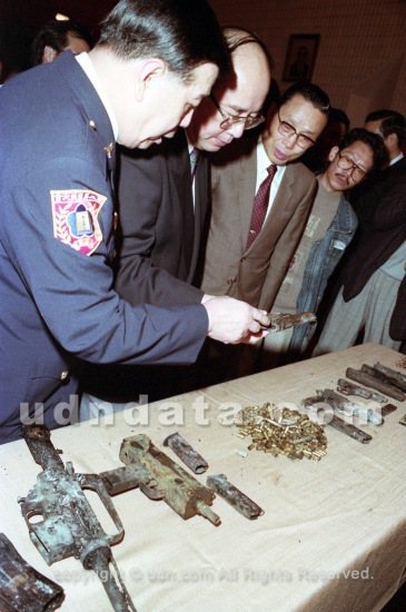 警方「獵龍專案小組」台北市警政署長莊亨岱與內政部長吳伯雄觀看槍戰後留下的槍枝與彈殼。 聯合報系資料照（1992/04/11 林建榮攝）