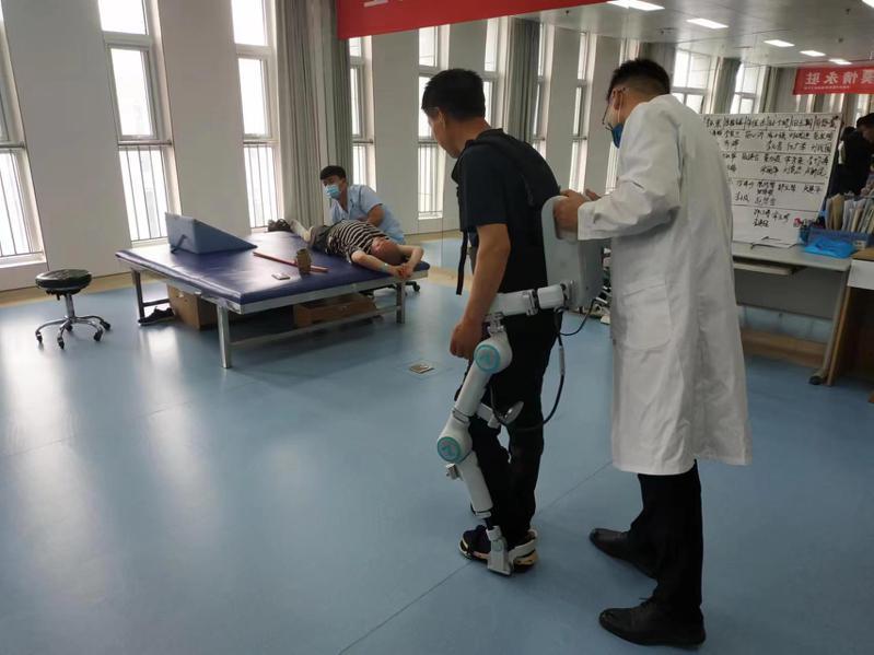 在河南省濟源市中醫院接受治療的病患在醫師協助下，使用康復機器人進行復健。記者黃雅慧／攝影