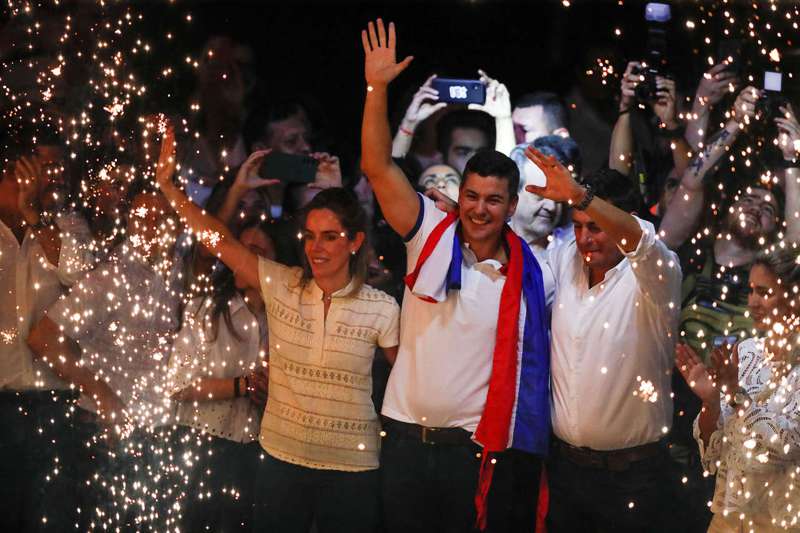 紅黨候選人潘尼亞（中）4月30日當選巴拉圭總統，當晚在首都亞松森市的該黨中央黨部，偕妻子奧坎波（左）感謝支持者與選民。路透
