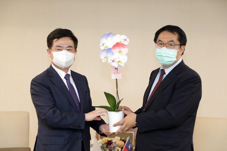 台南市長黃偉哲（右）致贈李殷鎬代表噴印蘭花。圖／台南市政府提供