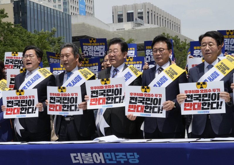 在野黨共同民主黨黨魁李在明（中）26日在首爾街頭發起連署抗議日本排房福島核汙水。（美聯社）