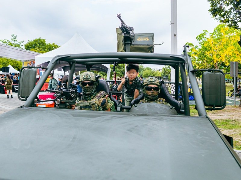 小朋友難得坐在特戰突擊車與全副武裝的軍人合影留念。記者古和純／攝影