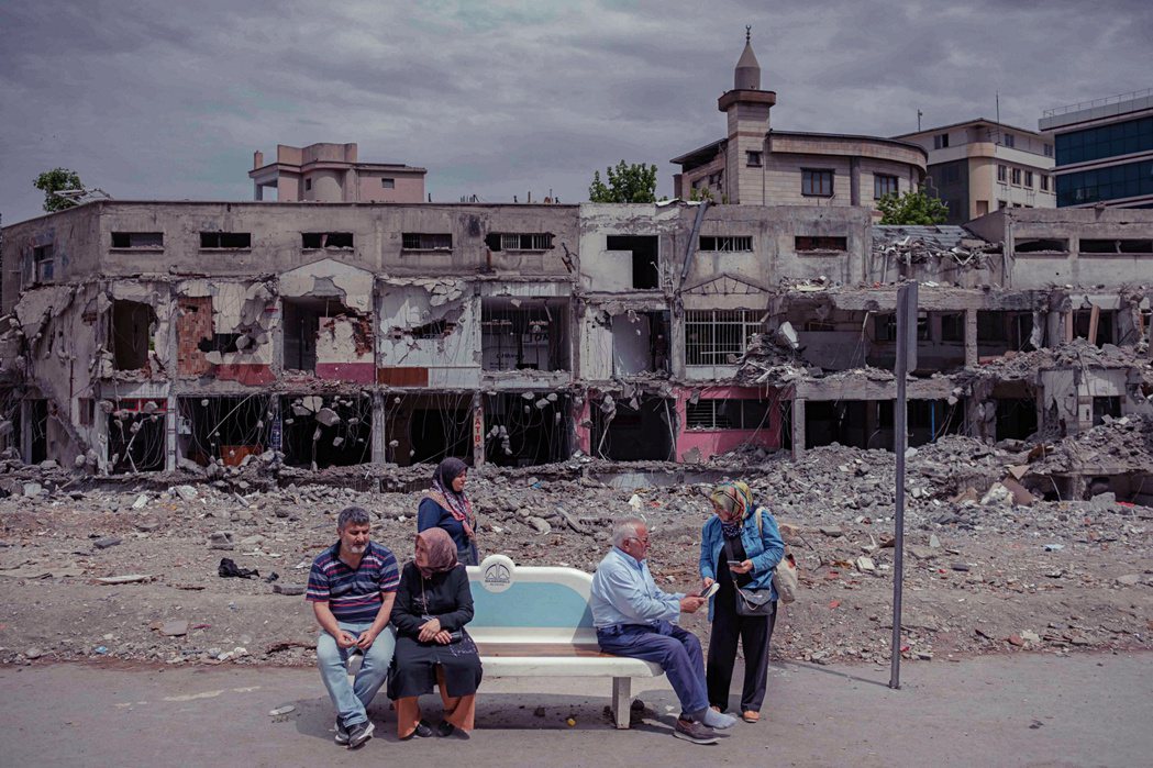 圖為5月28日，在土耳其地震重災區，民眾正在毀壞的建築物前等候公車。 圖／法...