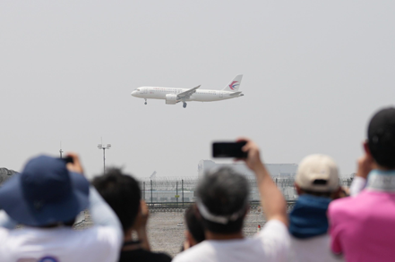 不少大陸民眾28日上午在上海虹橋機場外圍，興奮地觀看C919首次商業載客飛行。圖／新華社