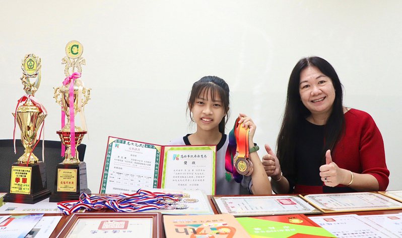 高雄今年有3名學生獲頒總統教育獎，其中一名為光華國中2年級學生李宜蓁（左），她自幼診斷出雙耳重度聽障，但仍樂觀突破障礙，將生命活得精彩。右為光華國中校長郭虹珠。（高雄市教育局提供） 中央社