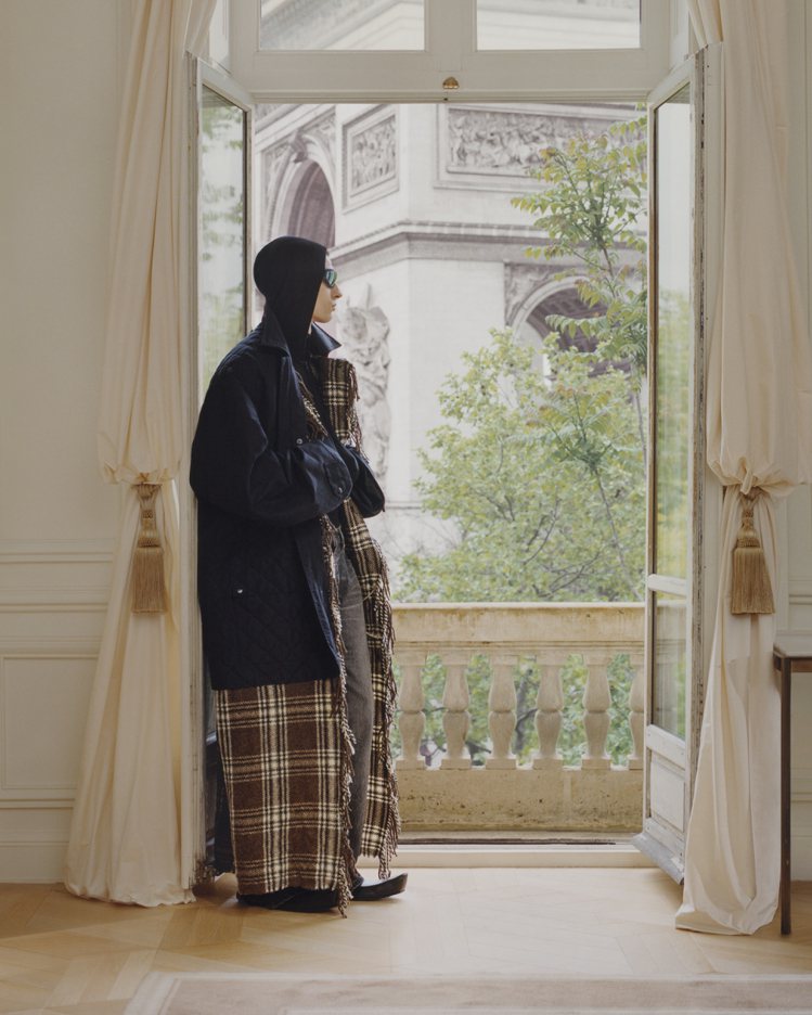 在拼接上流蘇格紋的鋪棉長夾克，風格遊走於家居和時尚之際。圖／Balenciaga提供