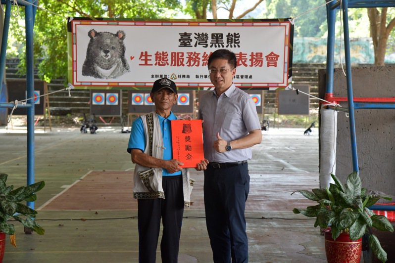 林務局長林華慶頒發獎勵金給通報並救援落難黑熊的茶園主人黃仁和。圖／花蓮林管處提供