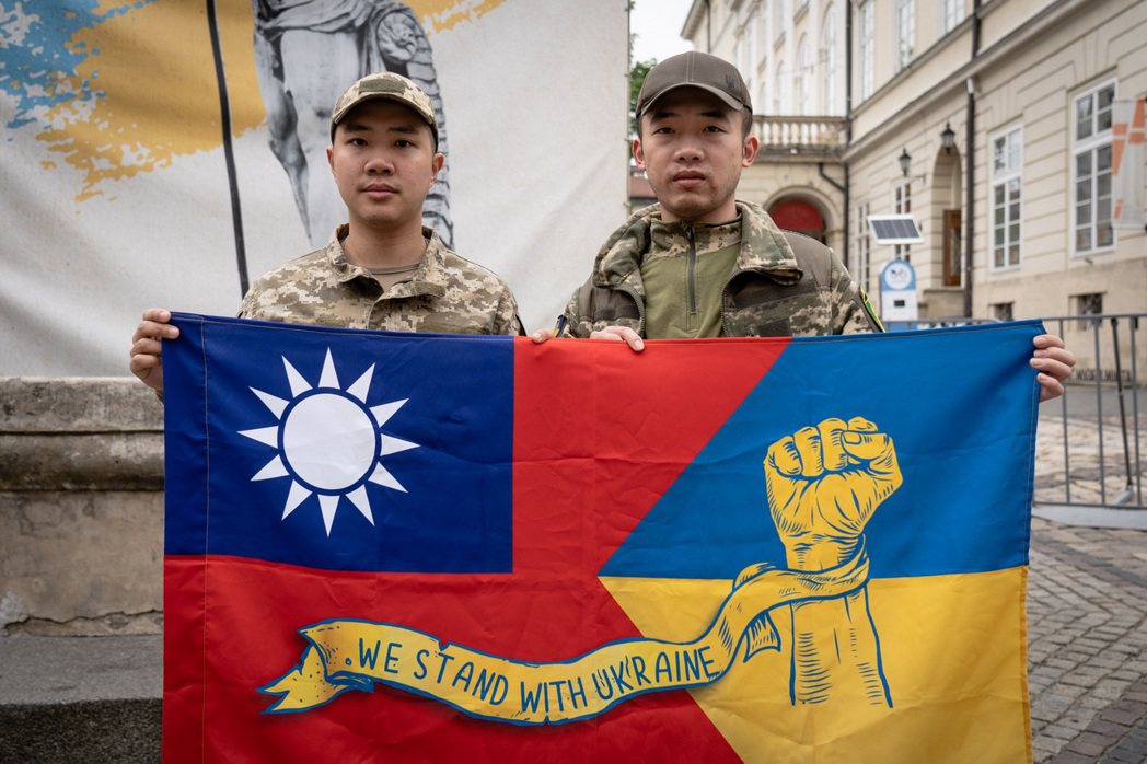 陳晞（左）與Cai（右）手持印有一半中華民國、一半烏克蘭的旗幟，上面以英語寫著「...