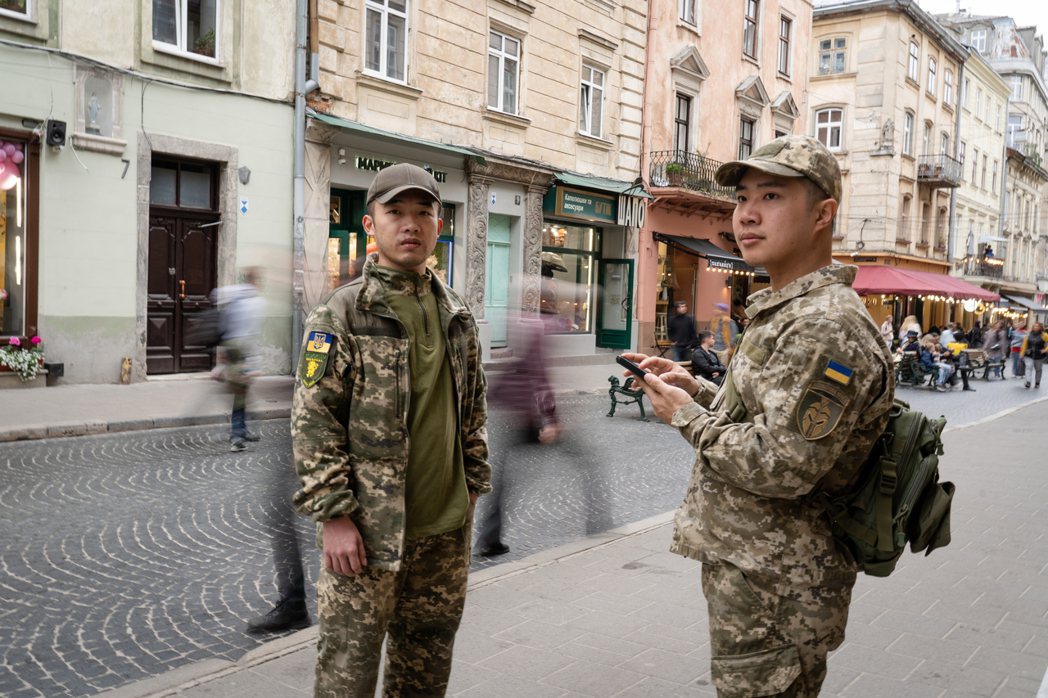 穿著軍服的陳晞（右）與Cai（左），在利沃夫市看到熙來攘往的大街也不太習慣。 攝...