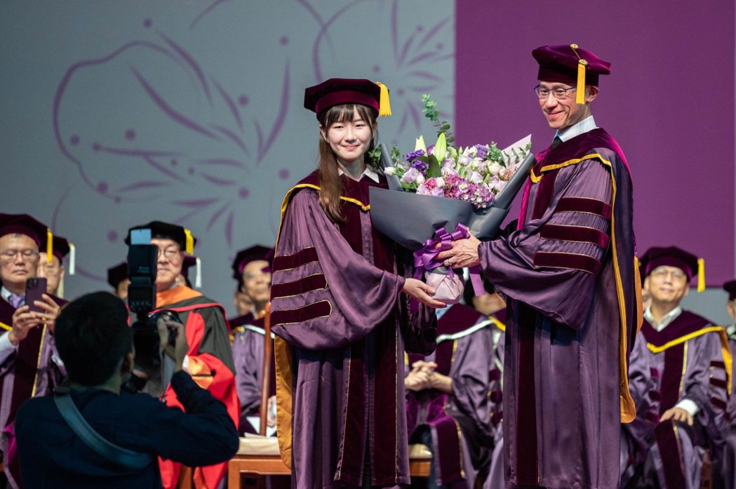 清大畢業生代表王祺嫻（左）獻花給校長高為元（右）。圖／清大提供