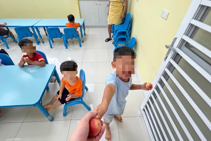 一位安置在南港關愛之家的小男孩看見記者，熱情分享水蜜桃。記者屈彥辰／攝影